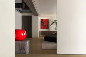 A modern living room with a wooden floor, concrete furniture, a potted plant, and a red abstract painting on the wall.