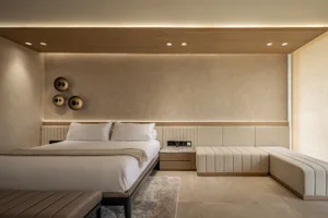 A minimalist bedroom with neutral-toned textiles and a modern design.