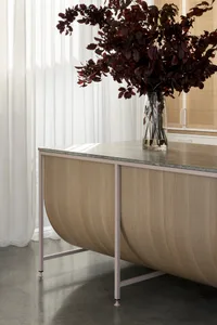 A modern, industrial-style metal desk with a marble top placed in an office setting.