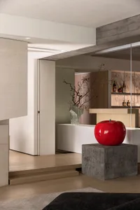 A minimalist living room featuring concrete walls and wooden furniture.