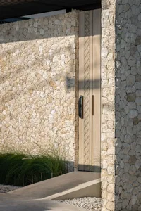 Modern residential entrance featuring stone and wooden elements.