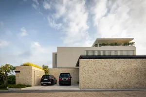 A modern minimalist home exterior with stone cladding and large windows