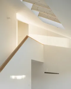 A modern staircase with white walls and wooden railings.