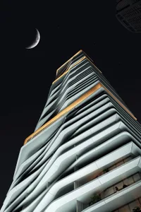 A modern building with a concrete facade at night under a crescent moon.