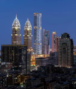 A nighttime cityscape featuring modern skyscrapers and illuminated buildings.
