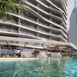 Modern apartment building with curved balconies and glass frontage overlooking a pool.