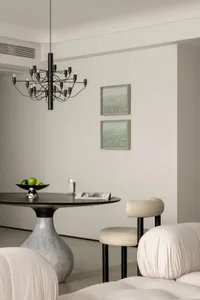A minimalist apartment showcasing marble, metal, and upholstered furniture.
