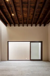 A minimalist interior design featuring concrete flooring and walls.