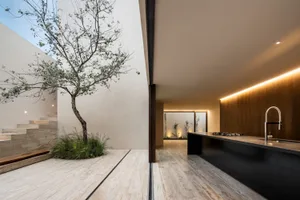 A modern kitchen with concrete floors, minimalist design, and a large island.