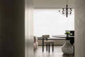 A minimalist dining room with a marble table and modern lighting fixture.