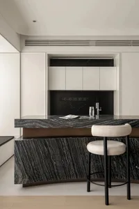 Modern minimalist kitchen featuring a black marble countertop and white cabinets.