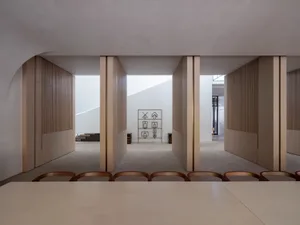 A minimalist interior with white walls and wooden elements.