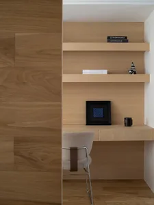 A minimalist office space featuring wooden shelves and a desk.