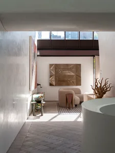 Modern living room featuring concrete walls, wooden flooring, metal accents, and upholstered furniture.