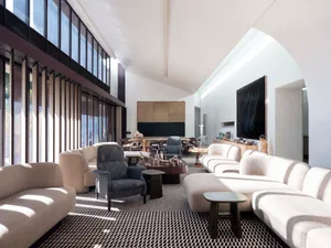 Modern living room featuring upholstered furniture, concrete flooring, and minimalist decor.