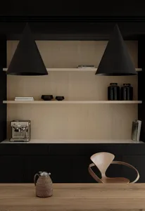 A minimalist home office featuring black metal pendant lights, a wooden table, and minimalist wooden shelves with black accen