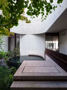 A modern residential entryway featuring a concrete courtyard.