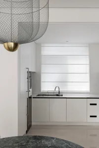 Modern minimalist kitchen with white cabinets and polished floor.