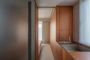 A minimalist bedroom featuring wooden paneling.