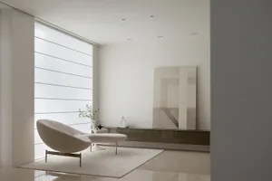 Modern minimalist living room with white concrete walls, floor, and furniture.