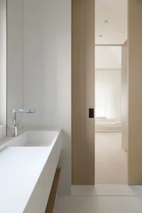 A bathroom with sleek, white surfaces and a minimalist design.