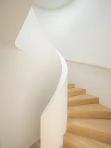 Modern, minimalist white staircase with wooden steps.