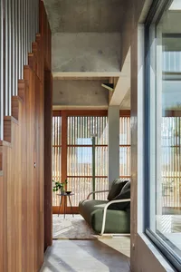 Industrial-style living space featuring wood accents, concrete structure, and glass elements.