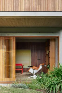 Modern minimalist living space with a slatted wood feature wall and furniture.