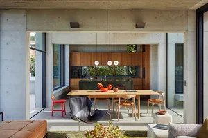 A modern kitchen with wood cabinets and a concrete floor.
