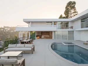 A modern residential building with a concrete exterior and a swimming pool.
