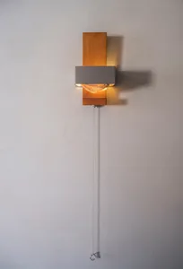A modern wall-mounted light fixture made of metal with a minimalist design.