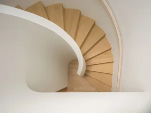 Modern, wooden staircase with white walls in a floor plan view.