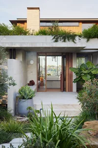 A modern house with concrete exterior and rooftop garden.