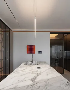 Modern minimalist residential kitchen featuring marble countertops and sleek, contemporary design elements.