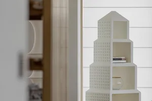 A modern, minimalist shelf with a decorative white design, featuring plastic material.