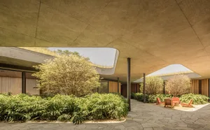 A modern living space featuring concrete flooring and numerous green plants
