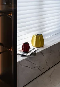 Modern console with marble top and leather bag on a marble ledge.