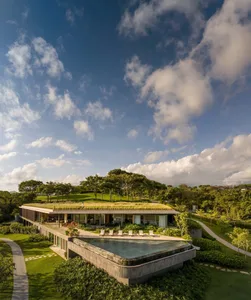 A modern house with a concrete exterior and a green roof.