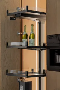 Modern kitchen featuring glass storage shelves with sleek, black metal framing.