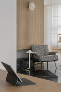 A modern living room with a marble floor, wooden walls, and a contemporary armchair.