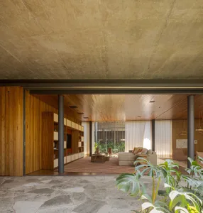 A modern living room features wood-planked flooring and a cozy seating area with comfortable furniture, providing a warm and 