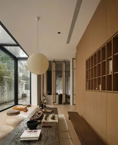 A minimalist interior design featuring wood, glass, and fabric elements.