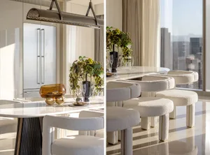 A modern, minimalist kitchen with marble countertops, glass elements, and metal accents, featuring elegant decor and sleek de