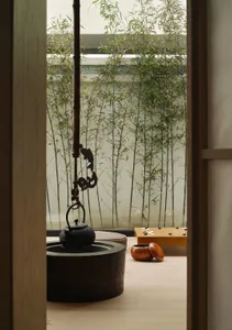 Minimalist living room featuring bamboo materials and a serene bamboo garden outside.