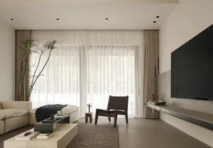 A minimalist living room with neutral-toned furniture, light-colored curtains, and a large floor-to-ceiling window.
