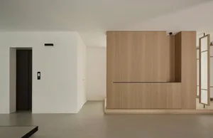 A minimalist residential space featuring wood and concrete materials.