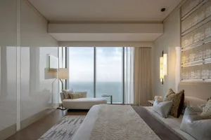 Modern bedroom featuring a large window with a view of the ocean.