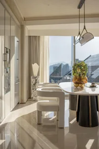 Modern dining room with marble table and chairs, featuring sleek, contemporary design elements.