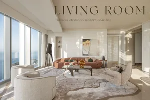 A modern living room with a large, round sofa, two armchairs, a coffee table, and a large window overlooking the coastline.