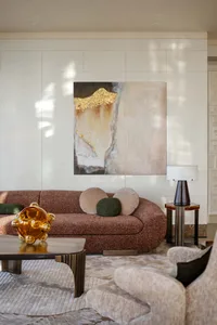 A modern living room featuring a textured fabric sofa, contemporary art, and a cozy ambiance.